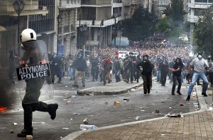 Görög rendőr menekül a tüntetők elől Athén, 2010 Május 5. (Forrrás: Wikipedia)